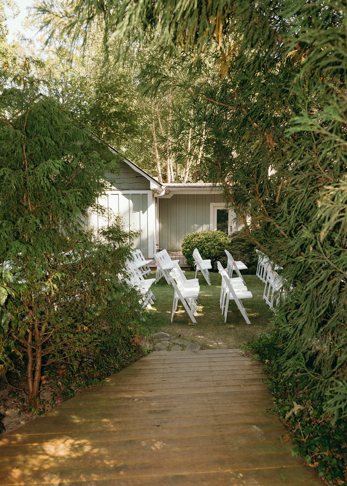 A pathway leads to a small outdoor seating area surrounded by greenery.